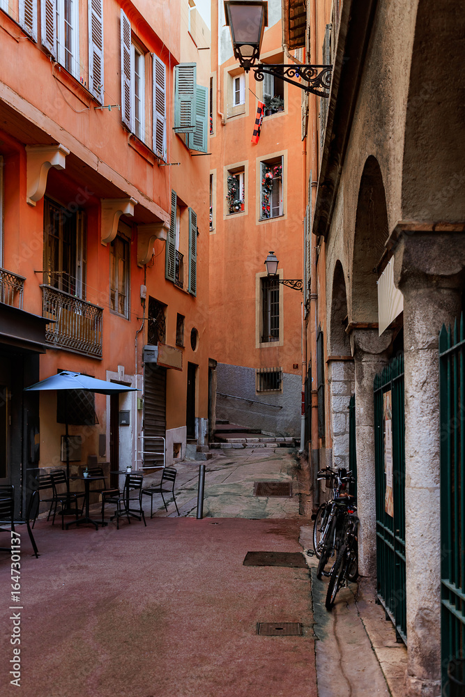 Obraz premium Narrow street in Nice, old colorful buildings in old town