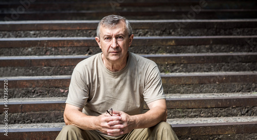 Pensive European senior man, emotional portrait of reflection and life challenges. Emotive portrait of a 55–65 year old man outdoors