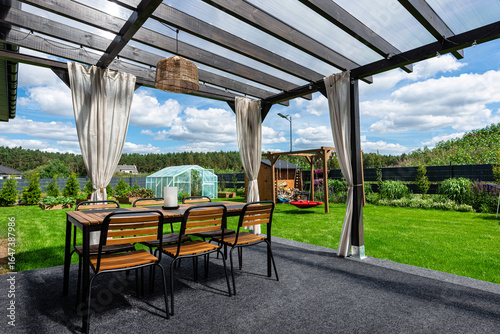 The terrace behind the house is made of beams, the roof is covered with polycarbonate.