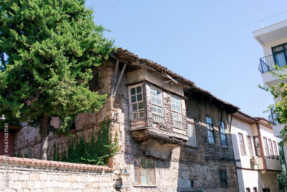 Building with a balcony and a tree in front of it Building with a balcony and a tree in front of it