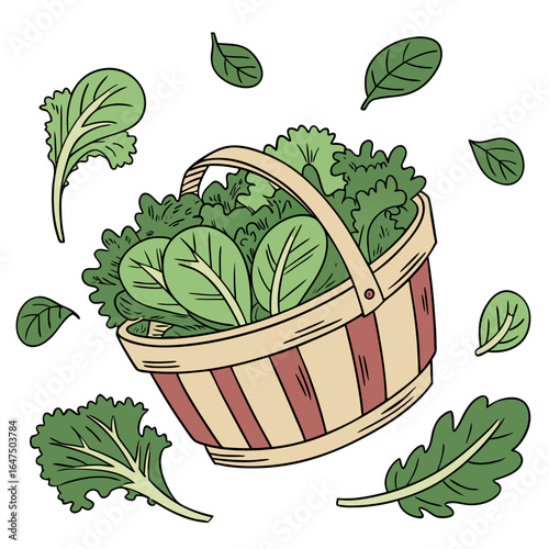 Freshly harvested green leafy vegetables in a wicker basket with scattered leaves