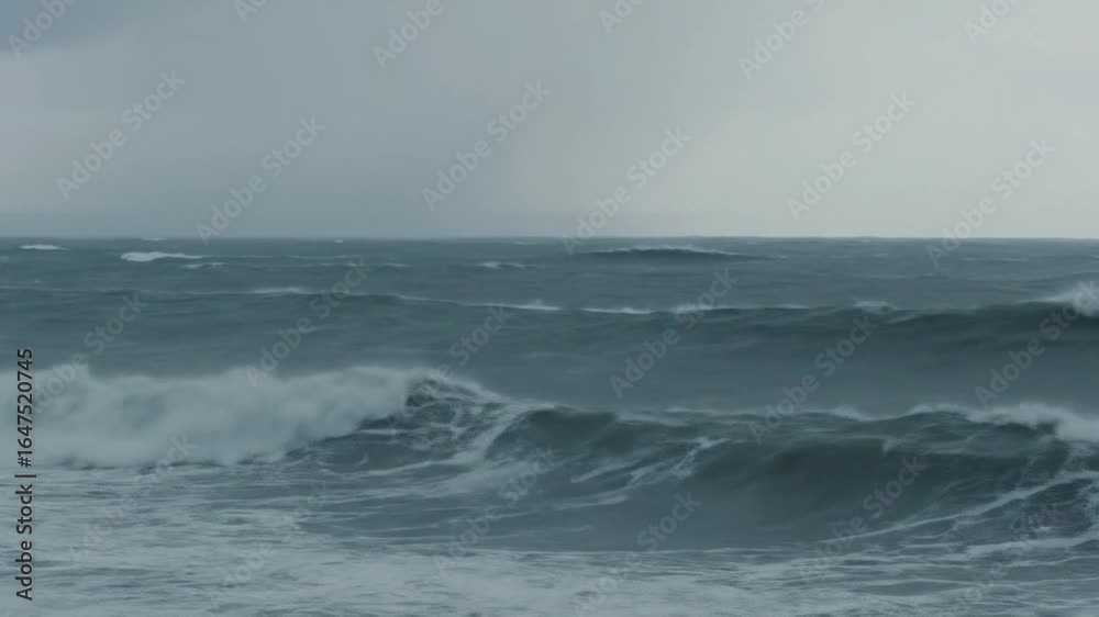 Powerful stormy ocean waves crash violently under a dark overcast sky showcasing the raw dramatic force of nature and a turbulent rough sea with heavy swell Powerful stormy ocean waves crash violently under a dark overcast sky showcasing the raw dramatic force of nature and a turbulent rough sea with heavy swell
