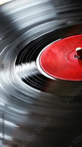 A record with a red label and a white label. The record is spinning and has a white label on the bottom