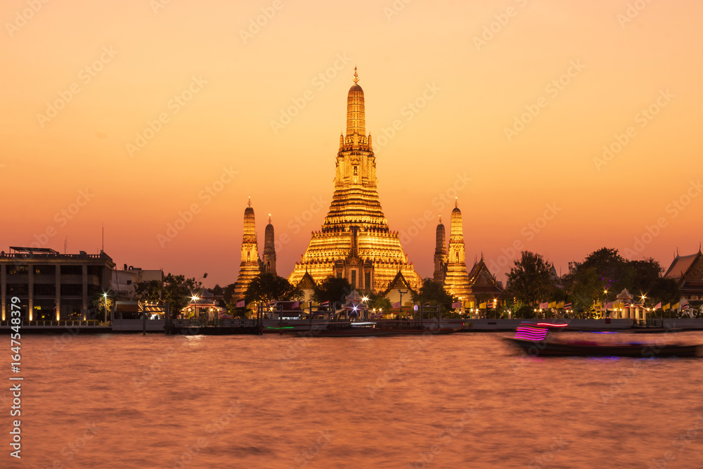 Fototapeta premium Wat Arun Ratchawararam Ratchawaramahawihan or Wat Arun (Temple of Dawn) is a Buddhist temple along the Chao Phraya river at twilight in Bangkok, Thailand.