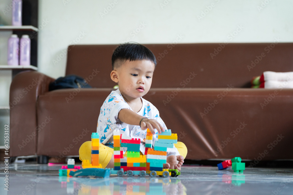 Fototapeta premium Child Playing with Colorful Building Blocks Indoors