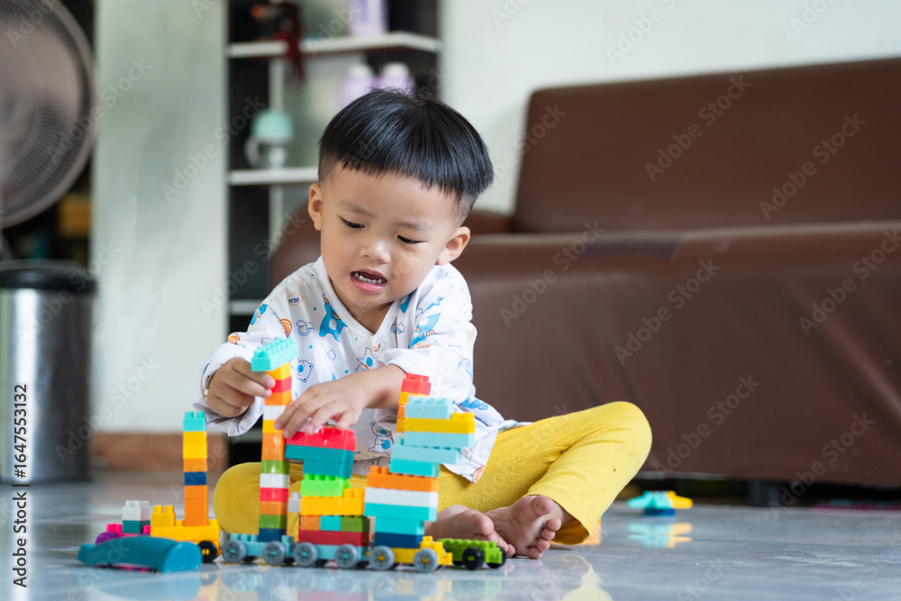 Fototapeta premium Child Playing with Colorful Building Blocks Indoors