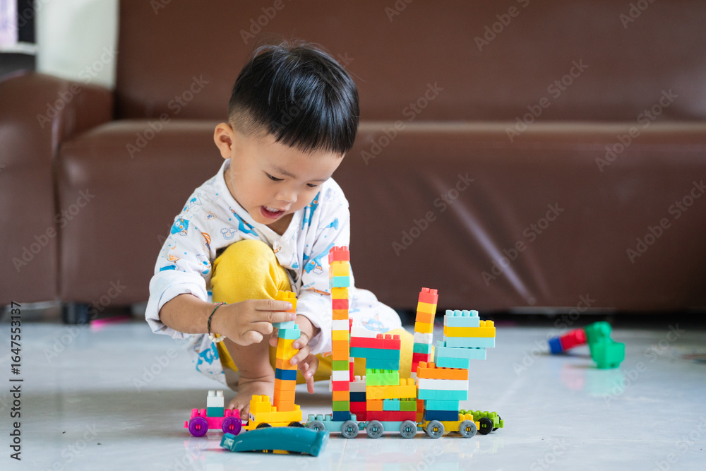 Obraz premium Child Playing with Colorful Building Blocks Indoors