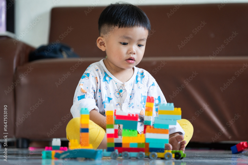 Fototapeta premium Child Playing with Colorful Building Blocks Indoors