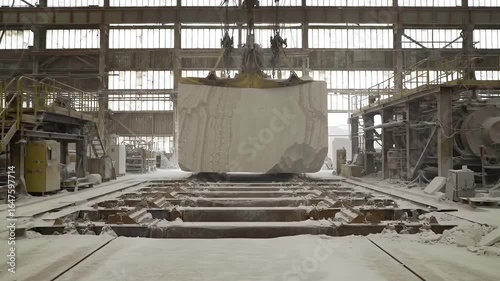 Massive Gray Stone Block Transported by Crane in Industrial Factory Setting