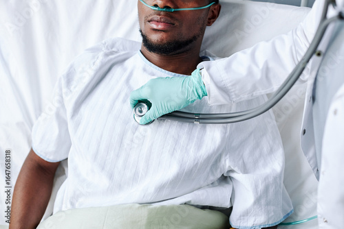 Wall Mural High angle view of unrecognizable doctor using stethoscope to listen to heart an