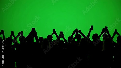 Audience captures event on phones against vibrant green screen backdrop, a moment of shared digital experience and anticipation for what's next.