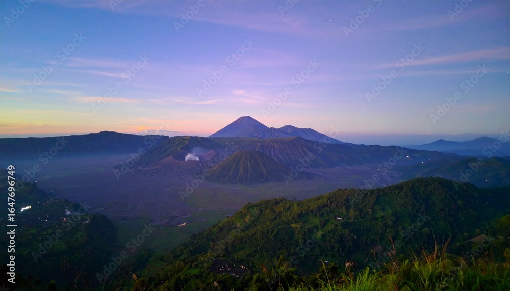 Fototapeta premium Majestic volcanic landscape at dawn with misty valleys and vibrant sky, evoking adventure and natural beauty.