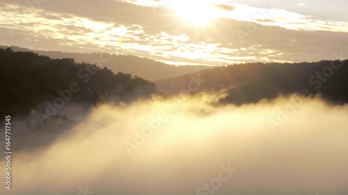 Golden sunrise over misty mountains, creating a serene and dreamy landscape view
