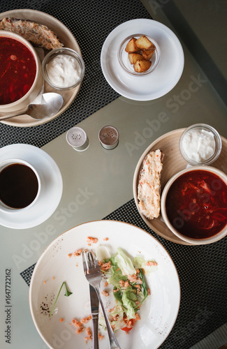 Wallpaper Mural Overhead view of an empty salad bowl with two bowls of borscht with sour cream, potatoes, a slice of garlic bacon dip on brown bread and a cup of black coffee Torontodigital.ca