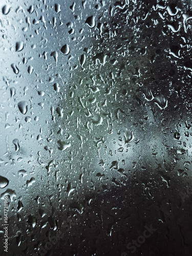 Drops of rain on a window pane, buildings in background. High quality photo