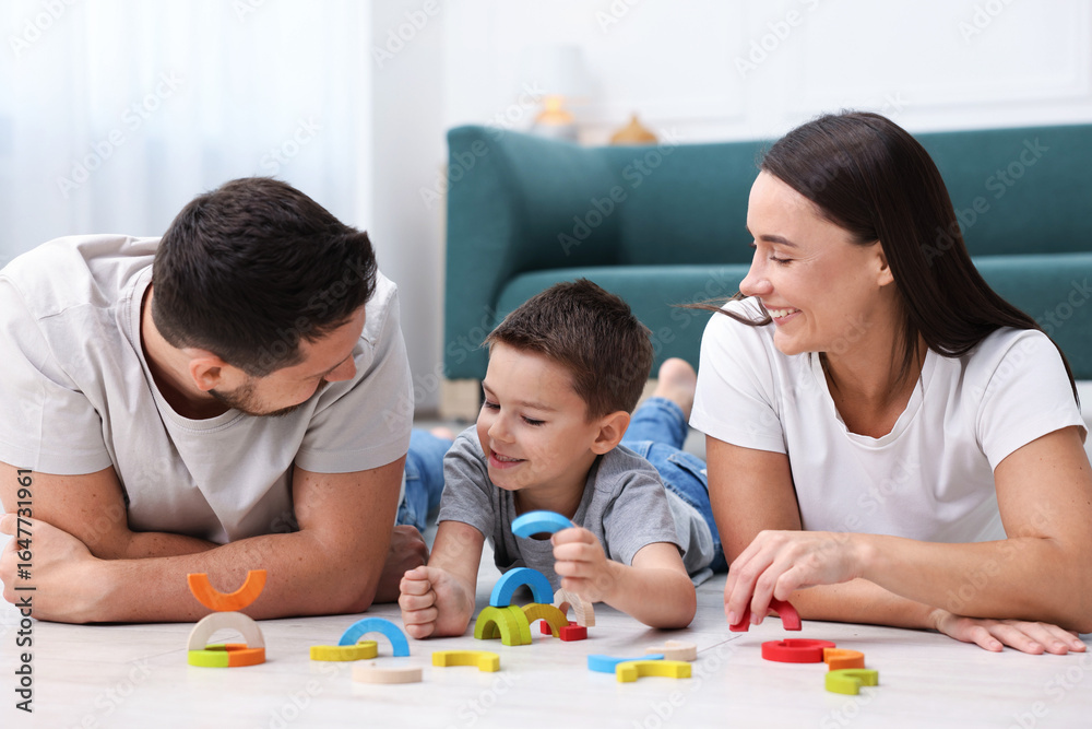 Parents and their son playing with toys on warm floor at home. Heating system Parents and their son playing with toys on warm floor at home. Heating system