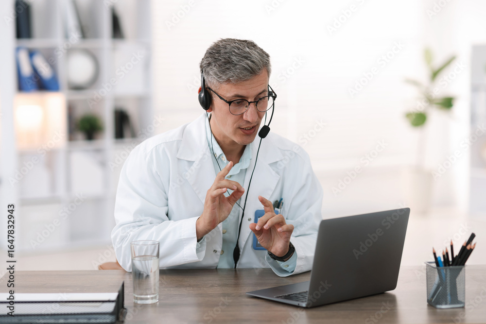 Obraz premium Telemedicine. Doctor having video call with patient via laptop indoors