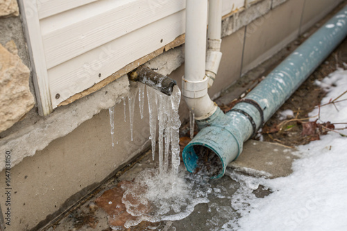 a frozen, burst water pipe in a north american home, with icicles forming