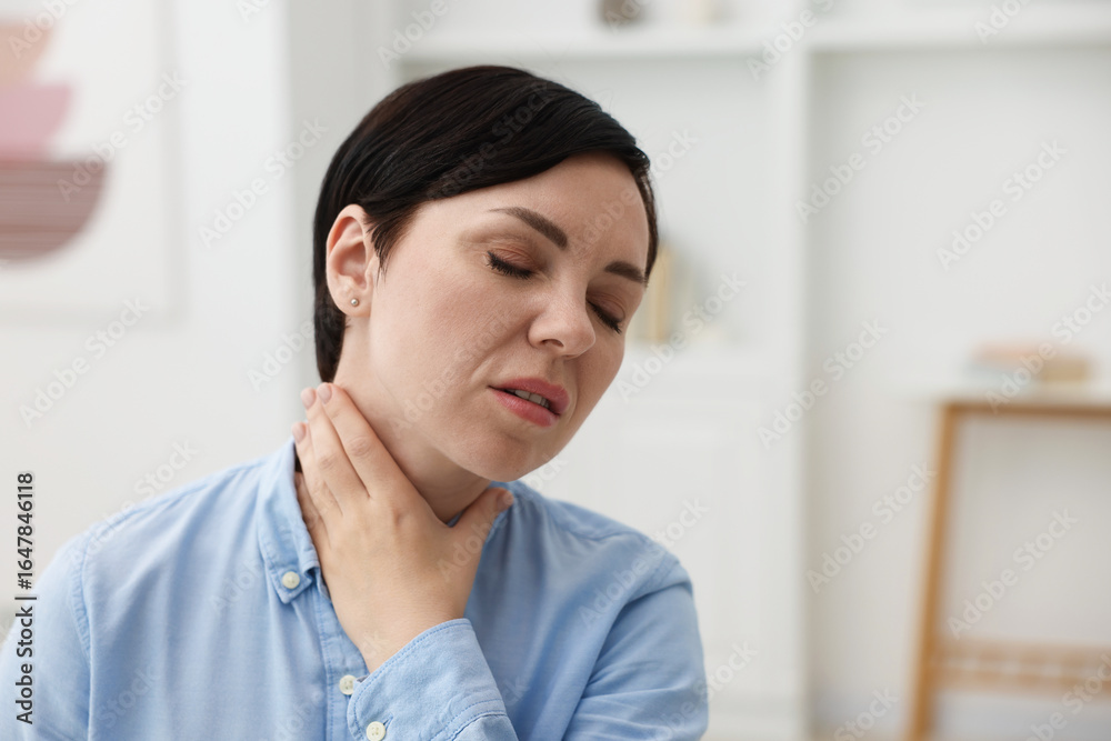 Obraz premium Woman suffering from sore throat at home. Space for text