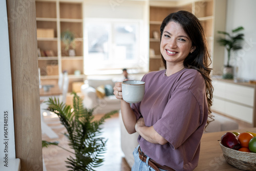 Fototapet Smiling woman enjoying morning coffee in modern apartment