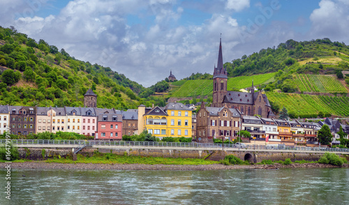 Cruising past the historic village of Bacharach am Rhein with the Wernerkapelle prominent in the skyline and its famous vineyard hills in the background, Rheinland-Pfalz, Hessen, Germany