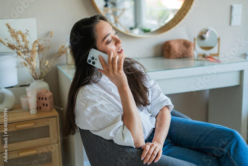 Young woman is having a phone conversation on a smartphone. Working online.