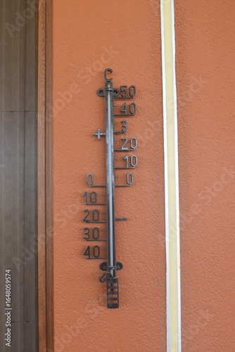 Thermometer in Celsius on the house wall on hot sunny summer day in Crete Greece