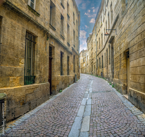 Fototapeta Naklejka Na Ścianę i Meble -  The fascinating cobbled streets of the old city of Boradeaux flanked by magnificent stone buildings in neo classical style, Bordeaux, Gironde, Nouvelle-Aquitaine, France