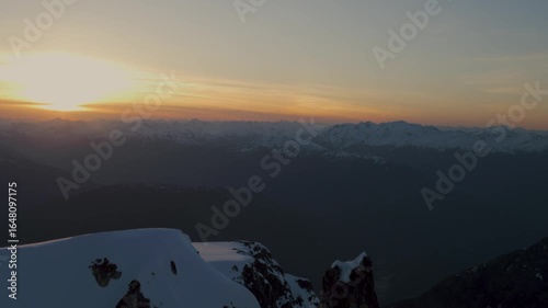 Epic aerial perspective of sunset over British Columbia Canada mountain peaks and glaciers
