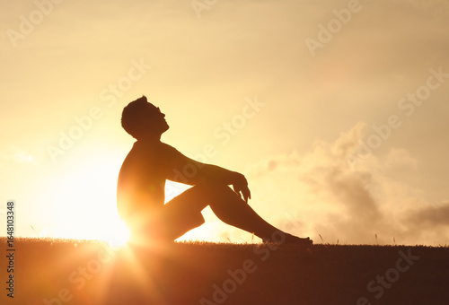 фотографія Young man looking up at the morning sun light sky finding happiness, peace and h