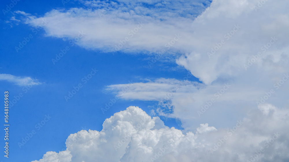 Naklejka premium Vibrant scene showcasing fluffy white cumulus clouds against deep blue sky, Ideal for backgrounds weather or peaceful nature concepts.
