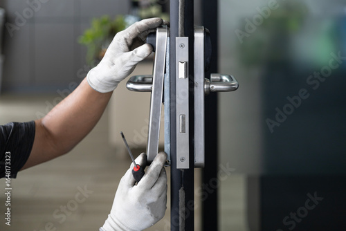 man repair the door lock in worker's hands installing new door locker