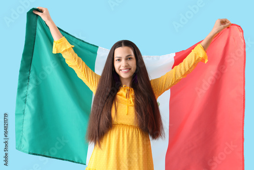 Young woman with Mexican flag on blue background