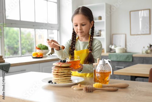 Cute little girl pouring ho...