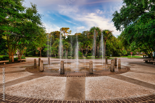 Tableau sur toile Multiple water fountains create a beautiful display in a serene park surrounded by lush greenery during late afternoon at Coligny on hilton head