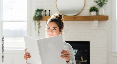 Young Woman Holding Blank Book in Bright Modern Home Living Room