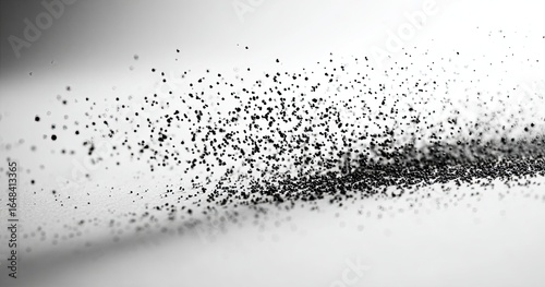 Abstract black particles dispersed across a light gray background
