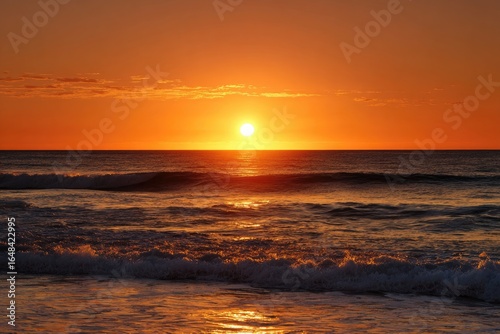 Vibrant sunrise over the ocean.  Sunrise, golden, waves, horizon,  ocean, sea,  beach,  morning,  sky,  warm,  orange,  red,  sun,  bright,  clouds,  calm,  water,  