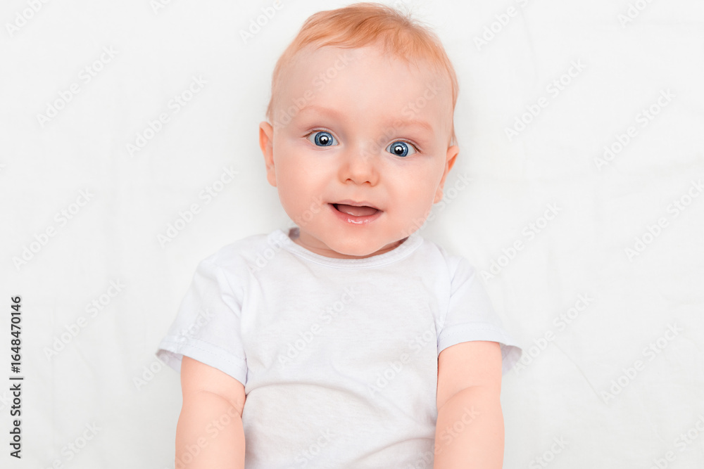 Portrait of a cute seven month old baby lying down smiling and looking at the camera Portrait of a cute seven month old baby lying down smiling and looking at the camera
