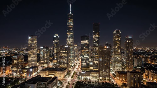 Wallpaper Mural Night City Skyline Timelapse - An aerial view of a modern city skyline at night, showcasing illuminated skyscrapers and busy streets below. Torontodigital.ca