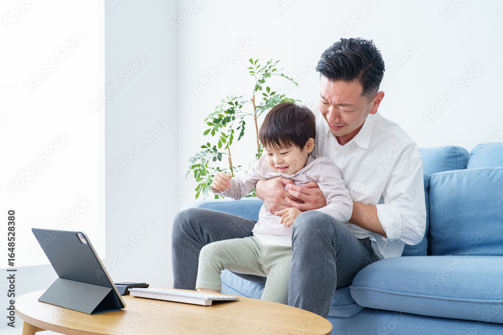 Fototapeta premium テレワークする父親を邪魔する子ども