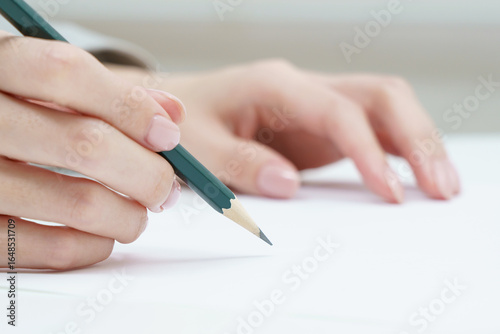 鉛筆を持つ女性の手
