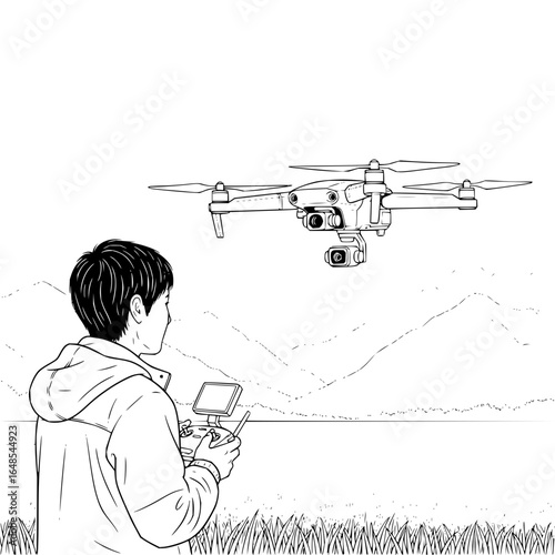 A young man operating a drone with mountains in the background on a sunny day in a grassy field