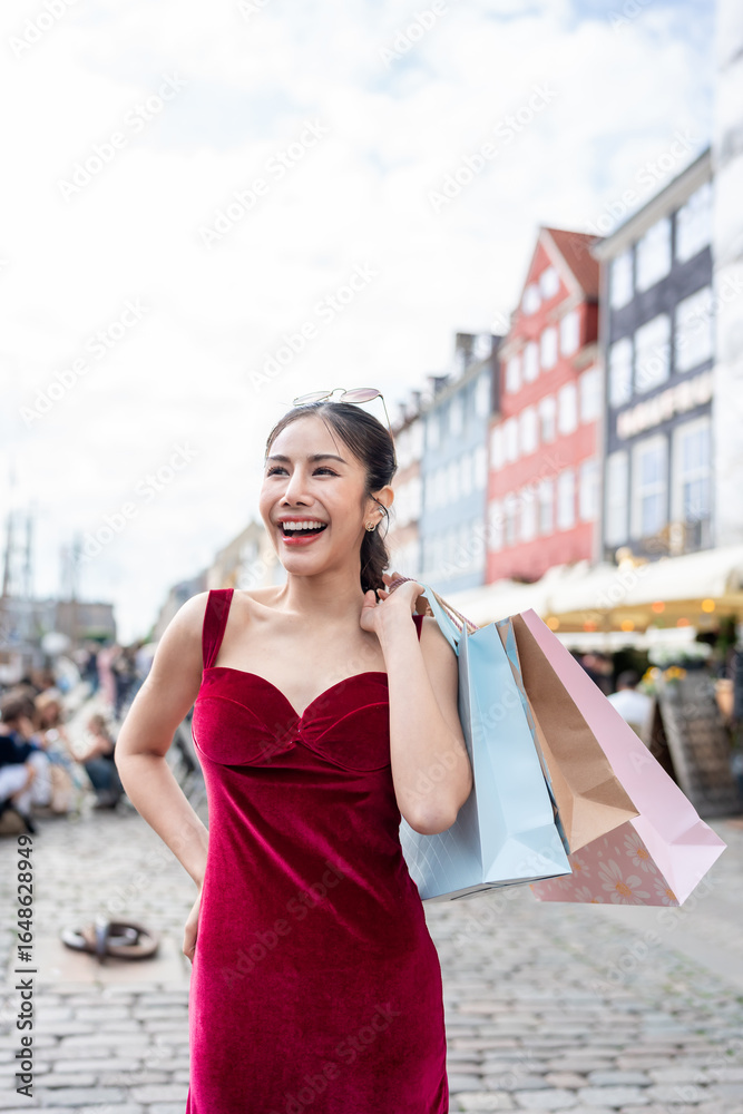 Fototapeta premium Asian woman holding shopping bags and walking at outdoors marketplace. 
