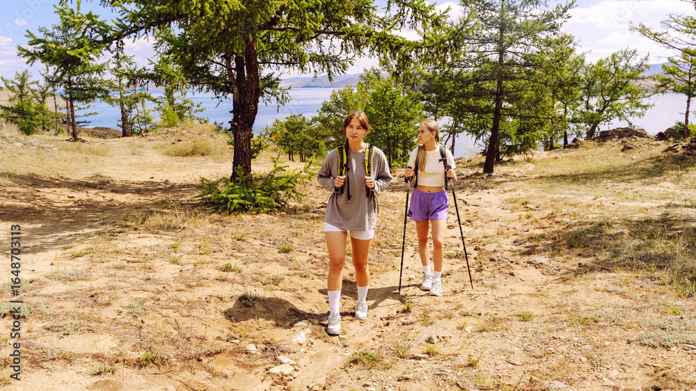 Fototapeta premium Hikers exploring a scenic trail near the lake on a sunny day