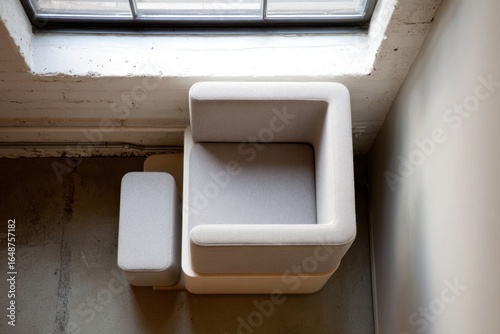 Modern, light-gray upholstered chair and ottoman, viewed from above