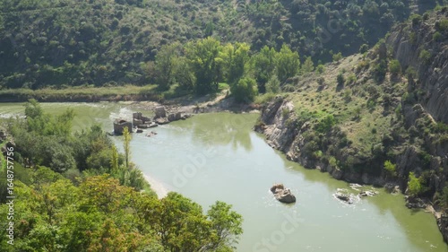 river with the ruins of a bridge in spain