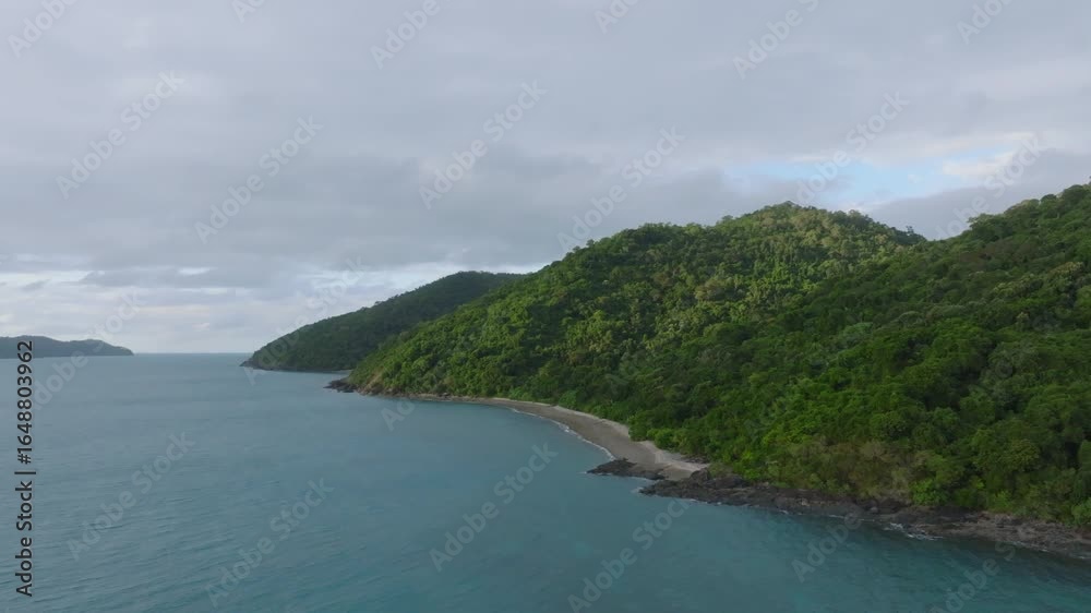 Aerial: Drone flying past a heavily forested tropical island in the Whitsundays, QLD Australia Aerial: Drone flying past a heavily forested tropical island in the Whitsundays, QLD Australia