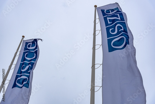 OSCE flags waving against a cloudy sky in Vienna, Austria