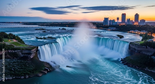 Panoramic view of Niagara Falls at sunset.  Vast cascading water, vibrant colors, city skyline in background